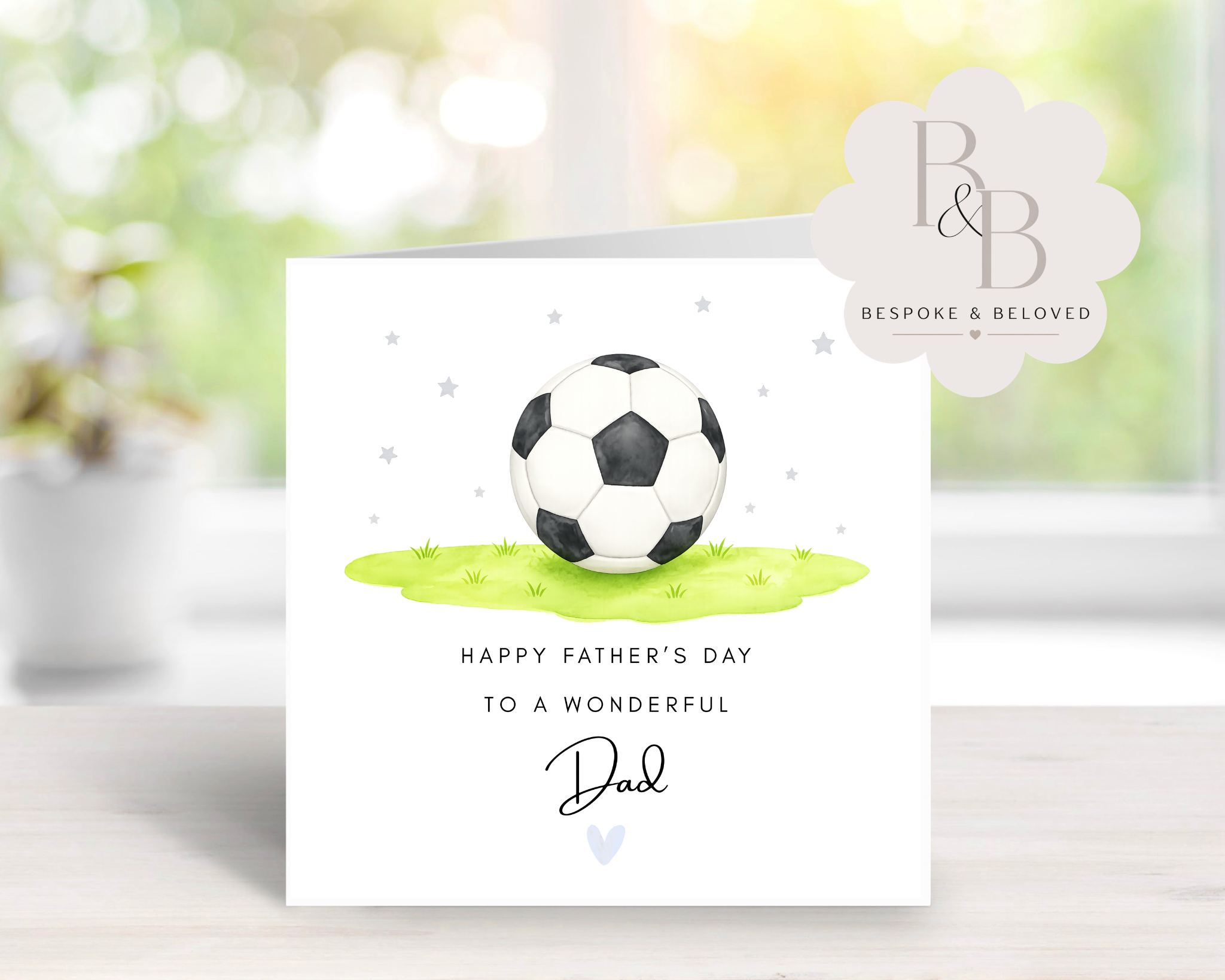 Father's Day card with a soccer ball on a grassy patch, featuring the text 'Happy Father's Day to a wonderful Dad'.