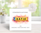 Greeting card with colorful license plate design and text congratulating someone on passing a driving test
